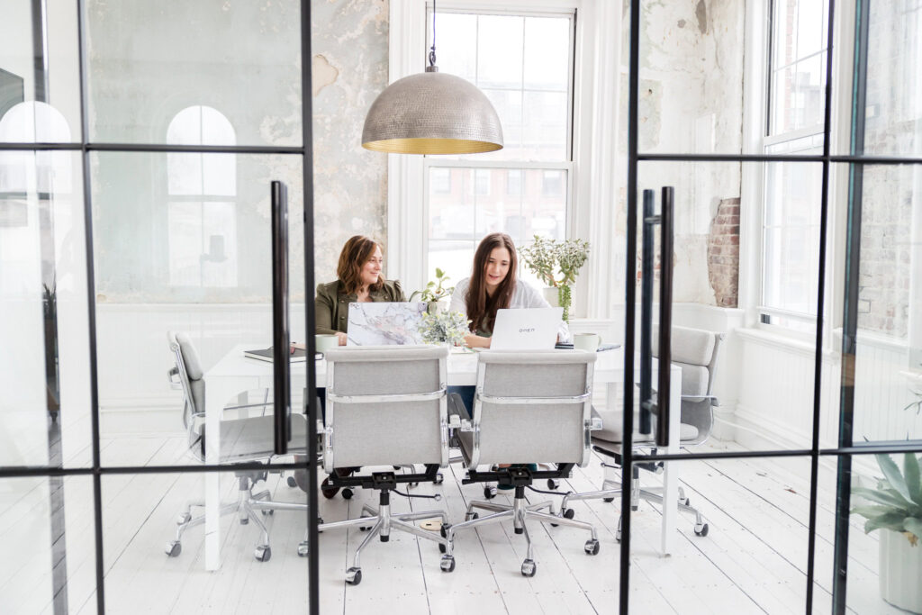 Megan and Lauren working a conference table on digital marketing strategy