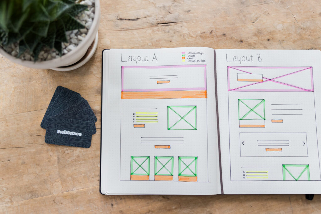 notebook on desk with website layout examples