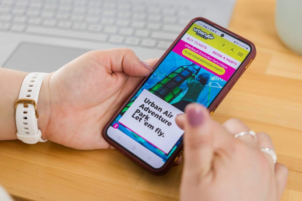 megan looking at the mobile version of urban air family entertainment franchise website