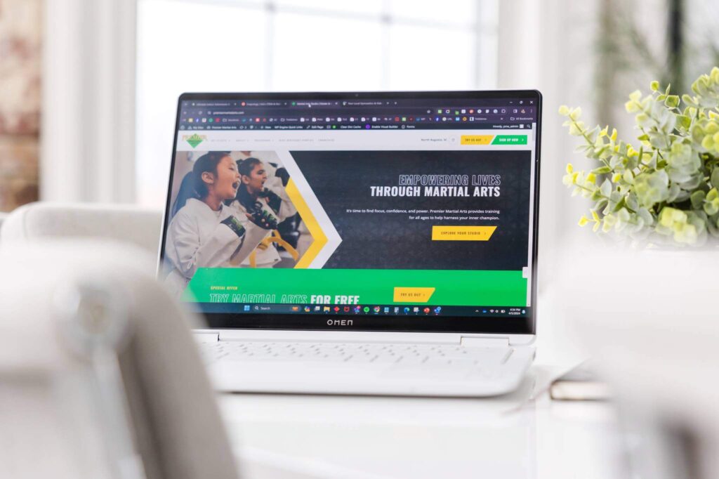 laptop sitting on a conference table showing the premier martial arts website homepage