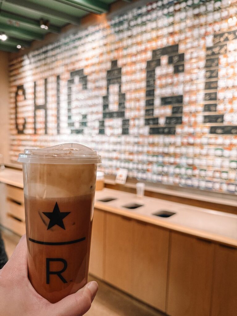 tiramisu latte being held in front of chicago mural at starbucks roastery
