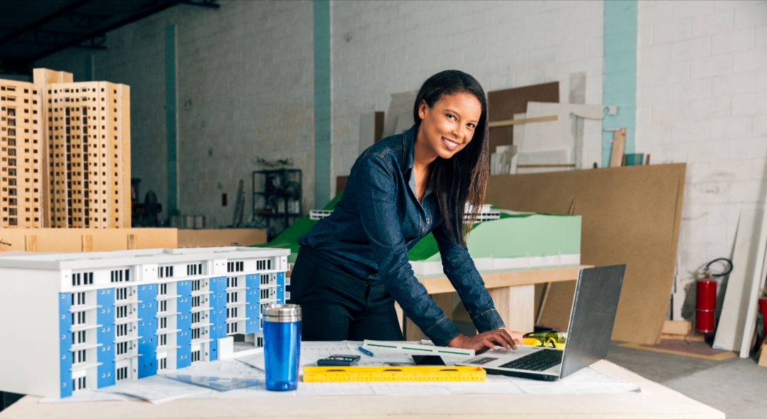 happy-african-american-lady-with-laptop-model-building-table