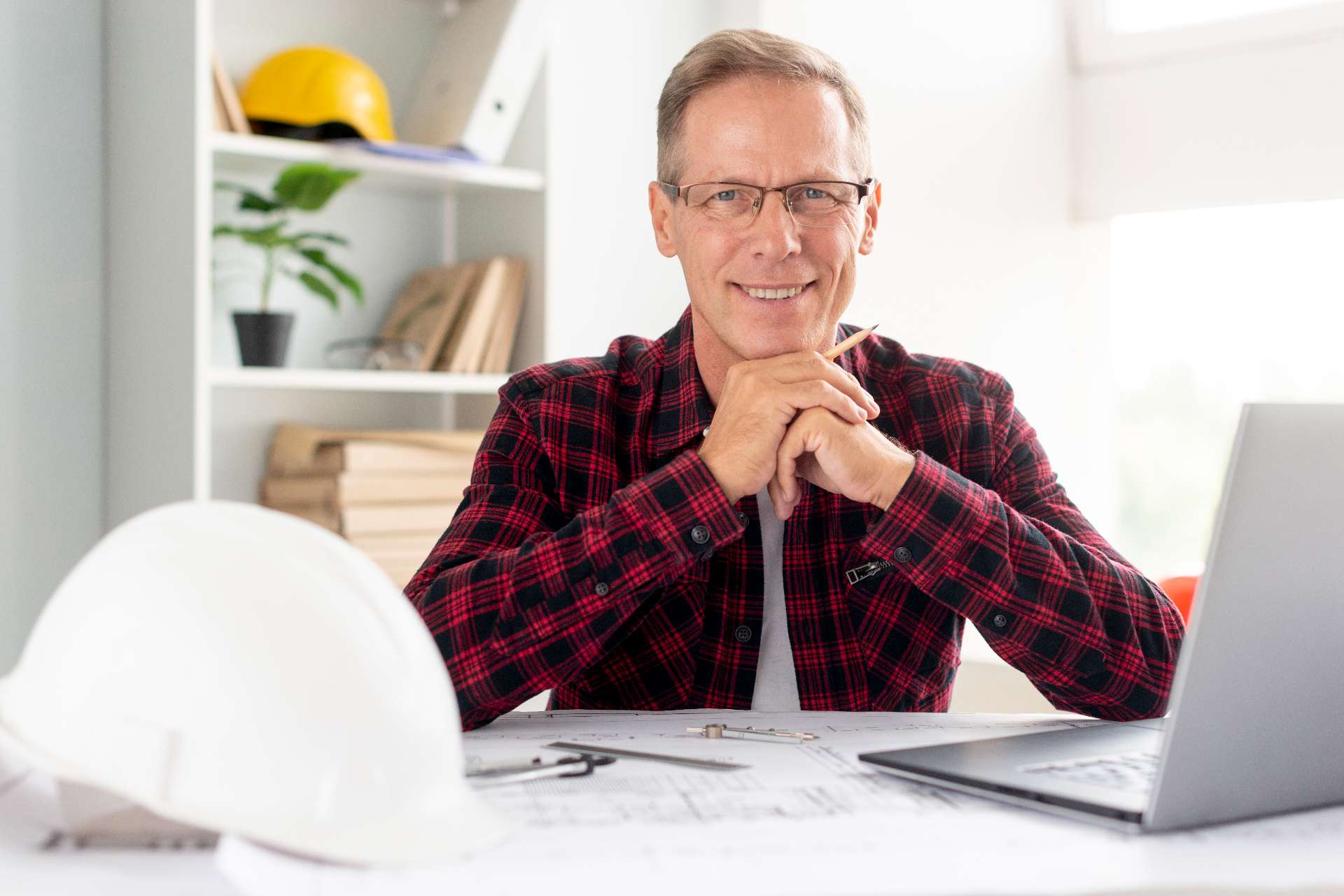 front-view-smiley-architect-looking-camera general contractor working at his computer