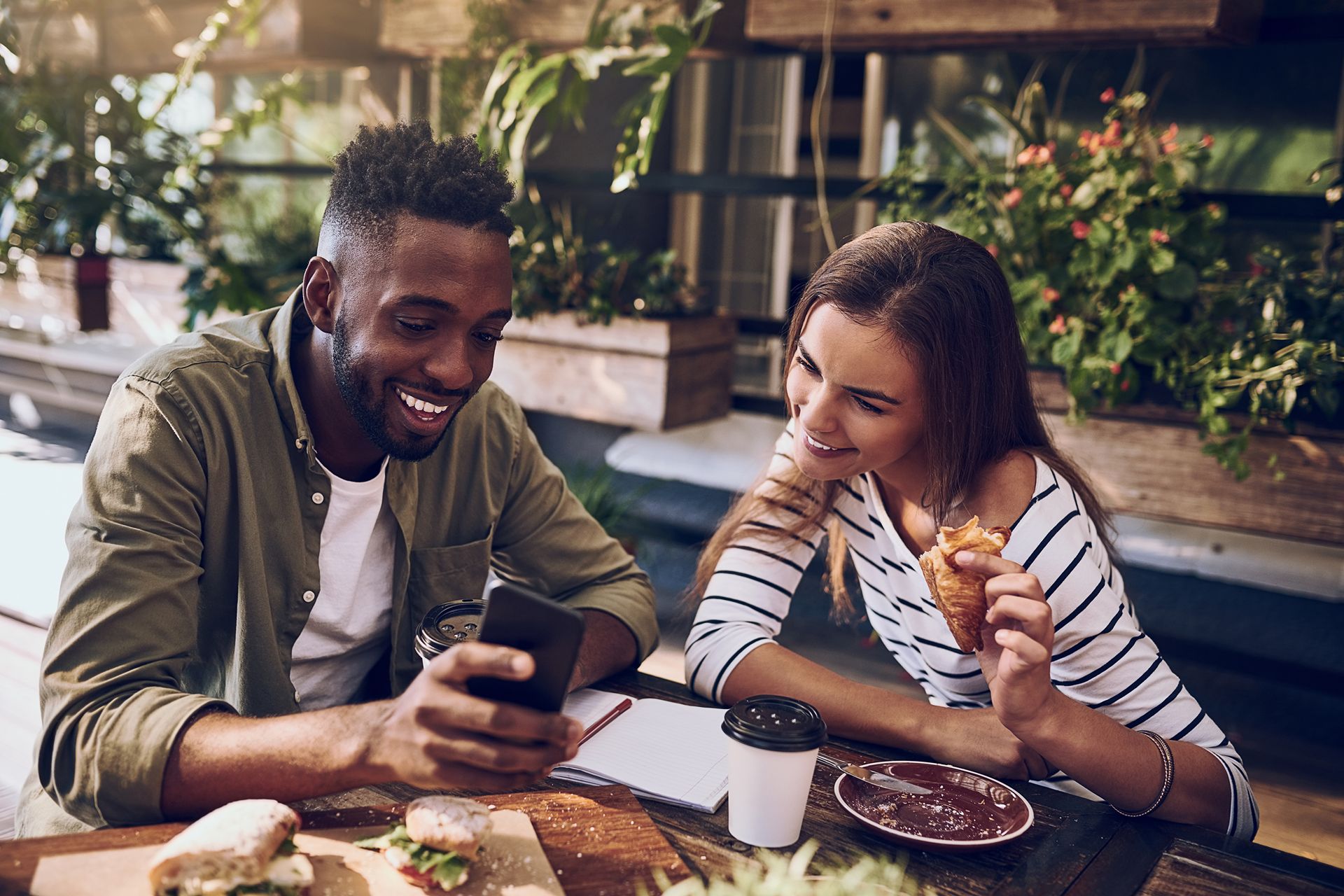 customers of qsr looking at cell phone while eating