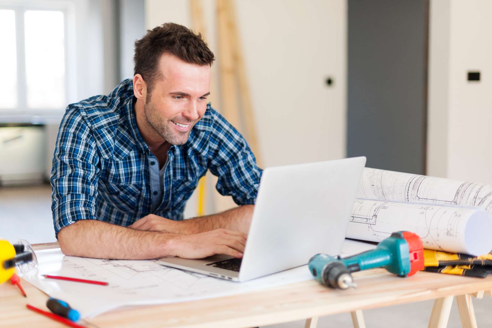 contractor looking at laptop enjoying the results of his digital marketing