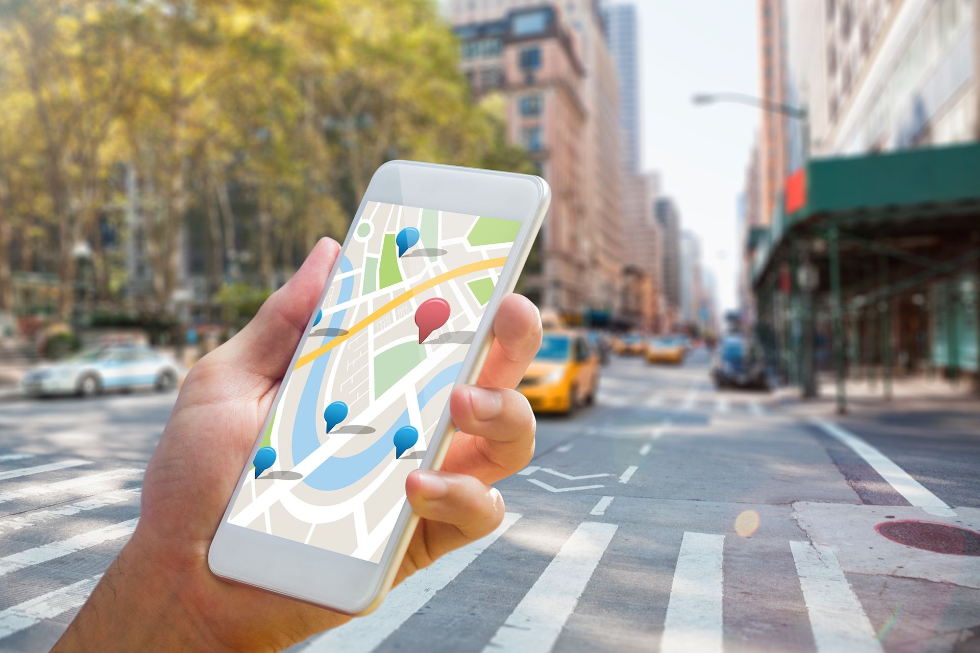 close up of map on cell phone with city street in background