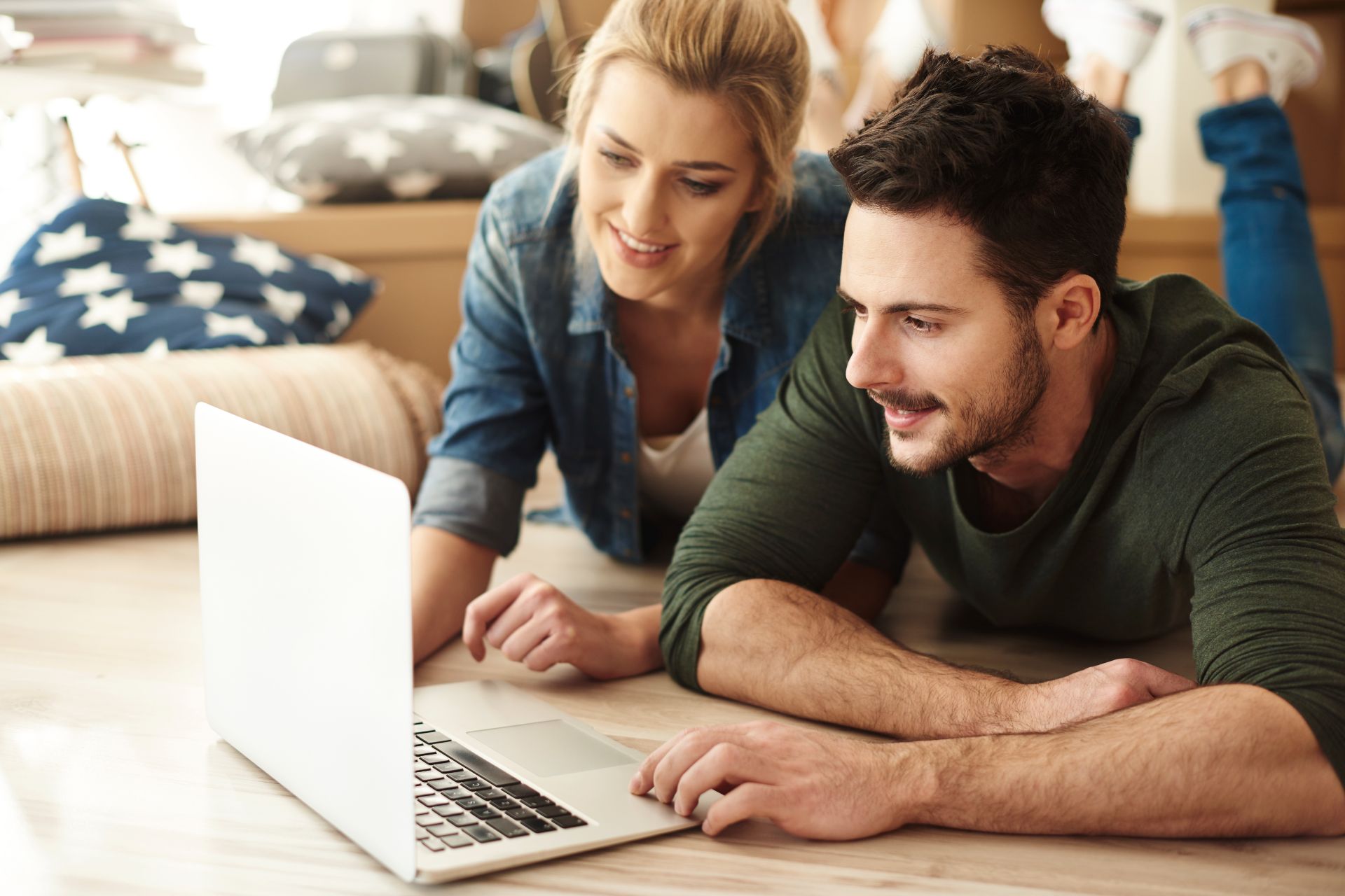 young couple looking at laptop for inspiration for swimming pool