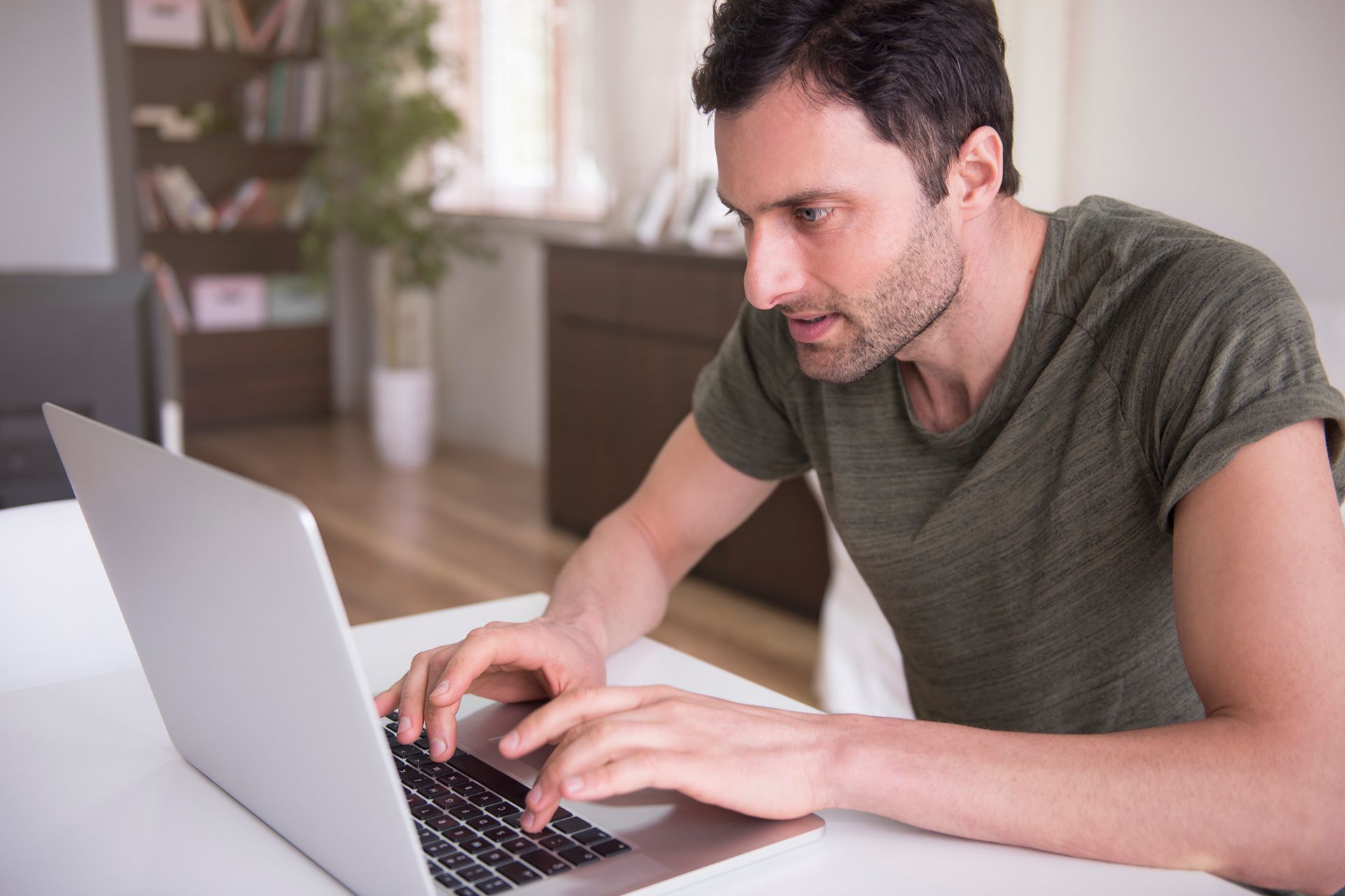 man searching on a laptop for a new dentist