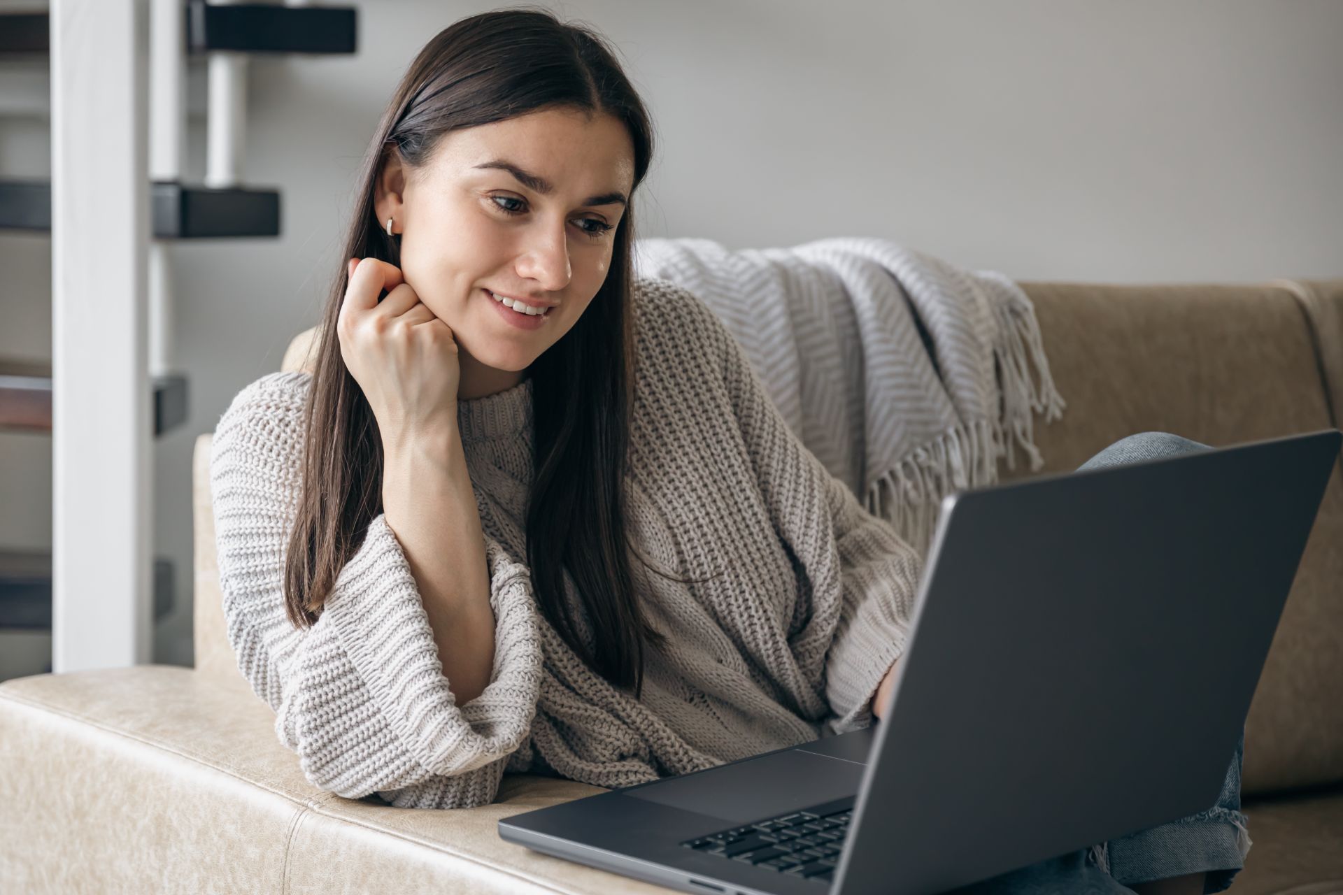 young woman smiles at laptop happy with the yoga studio website experience