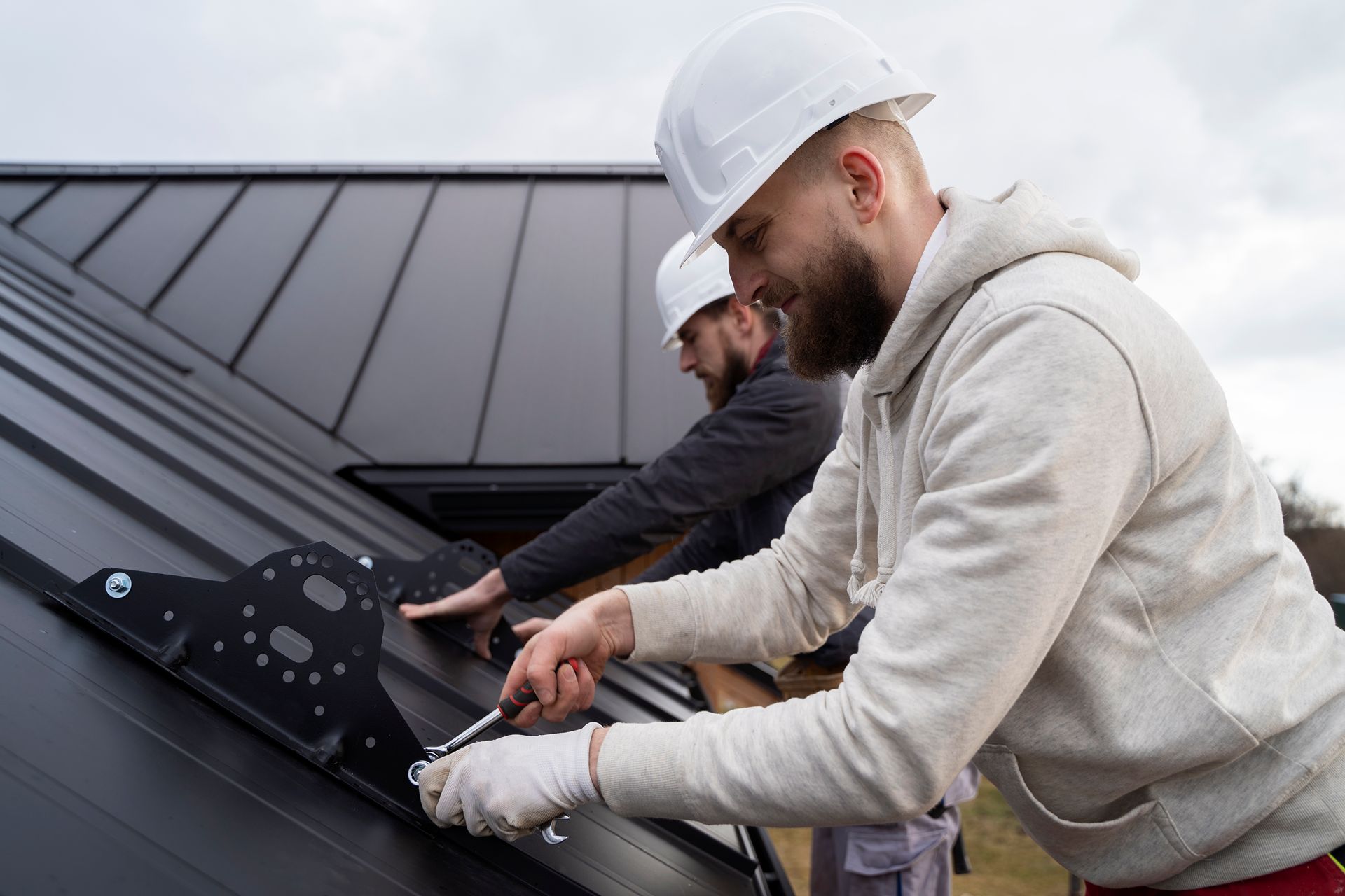 smiling roofer working on new metal roof
